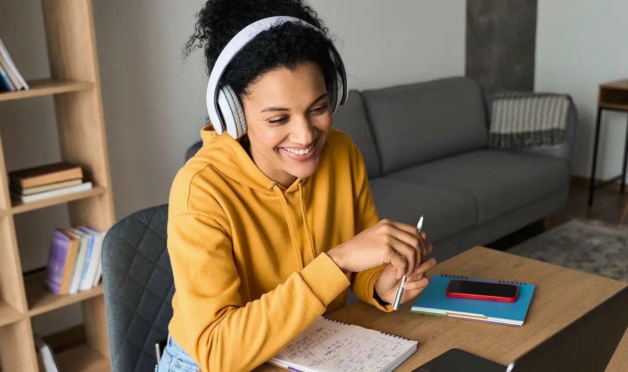 Mulher com fone de ouvido segurando um lápis