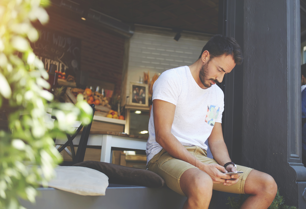 homem acessando celular internet - academia assaí