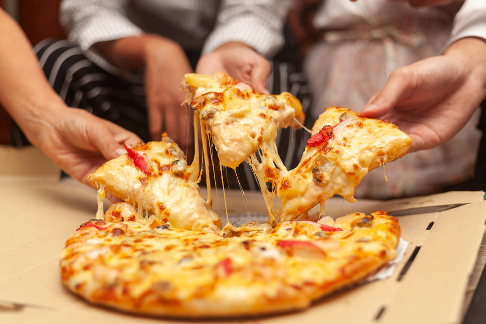 fatias de pizza com queijo derretendo - Academia Assaí