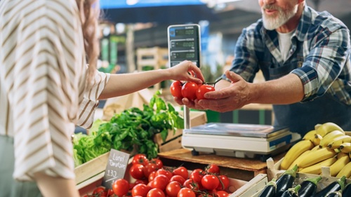 Feirantes - homem vendendo verduras em feira