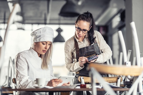 Empreendedora e funcionária usando ferramentas de precificação