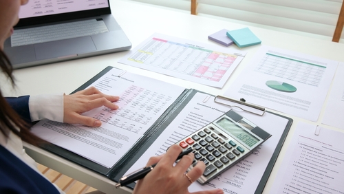 Empreendedora com papéis fazendo a gestão de fluxo de caixa