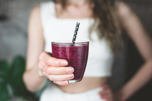 Mulher tomando copo de açaí