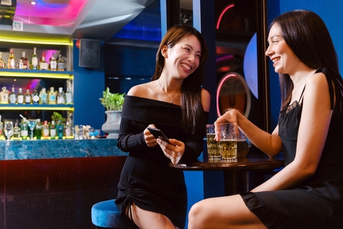 Mulheres seguras bebendo e conversando em bar