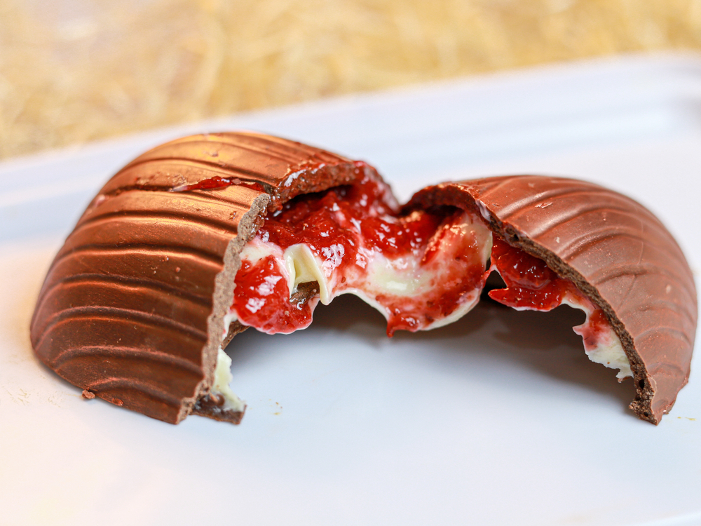 Ovo de Páscoa de chocolate ao leite com a casca recheada de geleia e creme.
