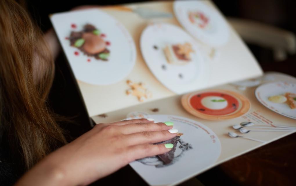 Mulher segurando um cardápio sazonal de fim de ano