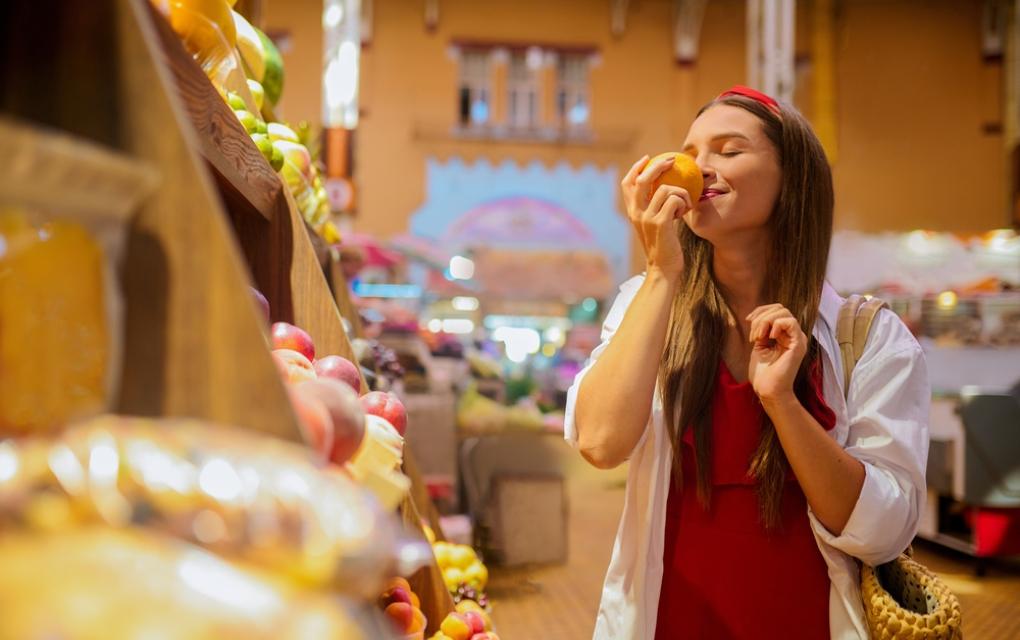 Cliente mulher sentindo aroma de laranja em mercado