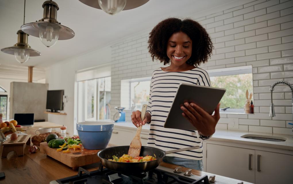 mulher cozinhando segurando tablet - academia assaí