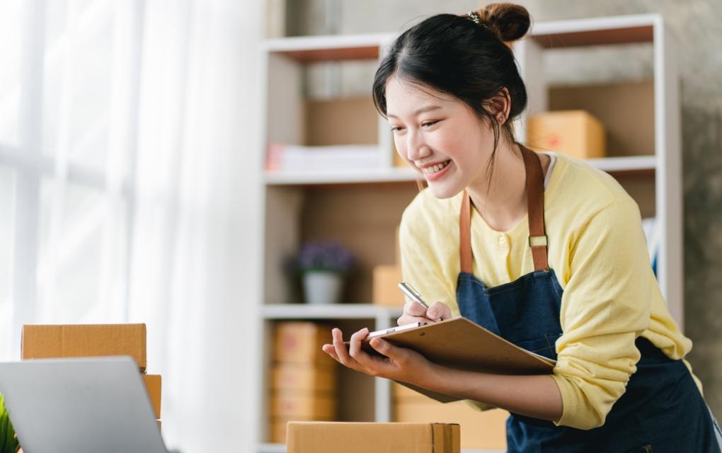 Mulher com caixas de encomendas e prancheta com prazo de entrega