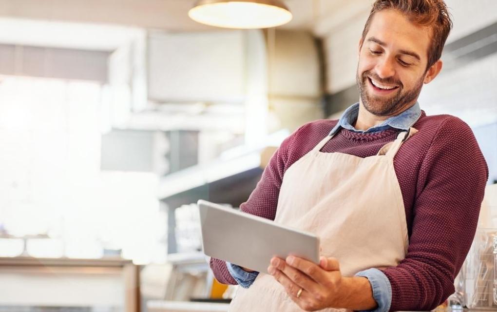 Restaurantes - dono de restaurante estudando feliz em tablet