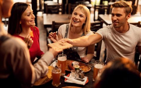 Amigos pagando cobranças de conta em bar