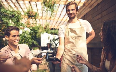 Casal pagando conta em restaurante com vale refeição