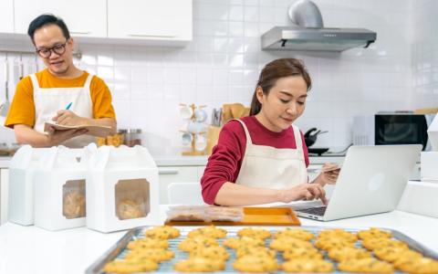 Casal de empreendedores usando ferramentas de gestão de encomendas