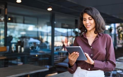 Mulher no tablet fazendo cursos gratuitos da Academia Assaí