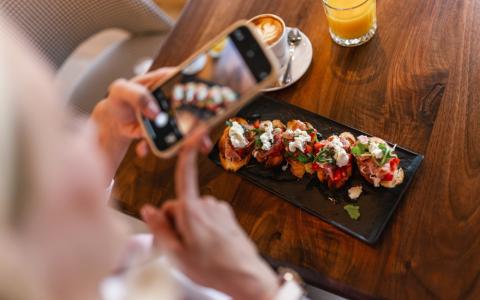 Mulher tirando foto de prato instagramável