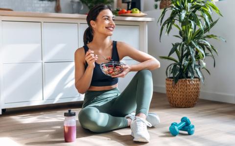 Mulher comendo receita de nutrição esportiva após exercícios físicos