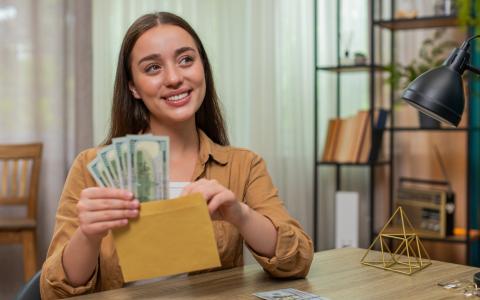 Mulher com hábito de guardar dinheiro em envelopes