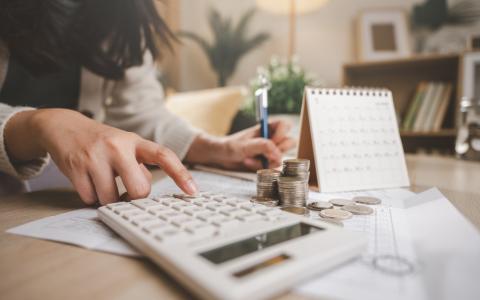 Mulher calculando impostos após reforma tributária 2026