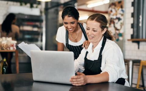 Duas mulheres fazendo o balanço de negócio alimentício