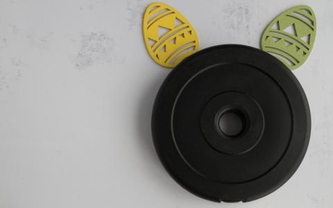 Peso de academia com ovos parecendo orelhas de coelho simbolizando páscoa fitness
